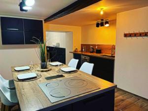 eine Küche mit einem großen Holztisch mit Stühlen in der Unterkunft L’insolite airbnb in Vignieu
