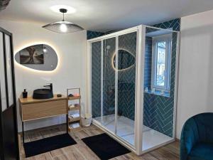 uma casa de banho com um chuveiro, uma secretária e uma janela. em L’insolite airbnb em Vignieu