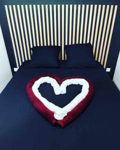 uma almofada de coração numa cama com uma colcha azul e branca em L’insolite airbnb em Vignieu
