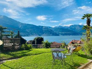 un patio con mesa y sillas y vistas al lago en Casa Vittoria, en Dervio