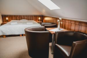a hotel room with a bed and chairs at Hotel nad morzem - Art-Pension - Dąbrowa - Holiday & SPA in Świerzno