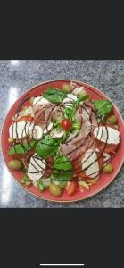 einen roten Teller mit Salat mit Fleisch und Gemüse in der Unterkunft Glessener Braustube in Bergheim