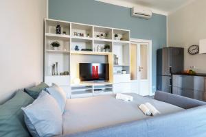 sala de estar con sofá azul y TV en [Duomo/Navigli] Casa Elegante in zona Tortona en Milán