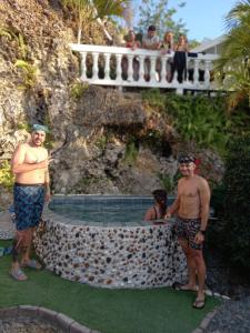 a group of men standing next to a swimming pool at The Rock House Eco in San Andrés