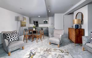 Keswick Lake Road Apartments في كيسويك: غرفة معيشة مع طاولة وكراسي ومطبخ