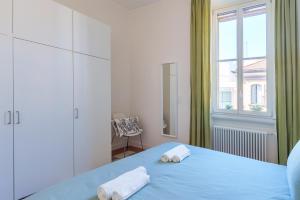 una camera con un letto blu e una finestra di [Duomo/Navigli] Casa Elegante in zona Tortona a Milano