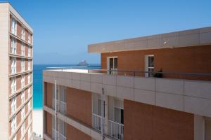 um edifício de apartamentos com o oceano ao fundo em 2 bdr cozy beachside apartment, Copacabana - LCGR em Mindelo