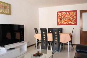 uma sala de estar com uma mesa e cadeiras e uma televisão em 2 bdr cozy beachside apartment, Copacabana - LCGR em Mindelo