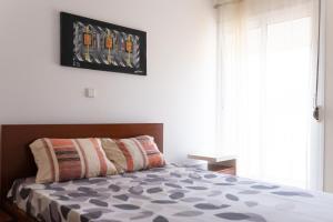 um quarto com uma cama e uma janela grande em 2 bdr cozy beachside apartment, Copacabana - LCGR em Mindelo
