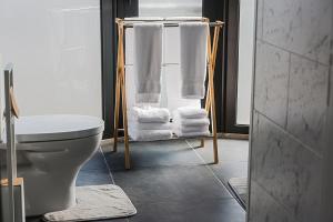 e bagno con servizi igienici e asciugamani su un appendiabiti. di Os Ninhos dos Avôs a Ponta Delgada Altre 29 foto