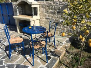 a blue table and chairs on a stone patio at UTOPIA RESIDENCES Kazantzakis House in Petrokefálion