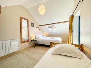 - une chambre avec 2 lits et un miroir dans l'établissement Pop House - Grand Jardin clos - BBQ - Spacieux & Lumineux, à Saint-Nazaire