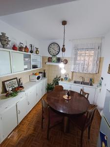 cocina con mesa y reloj en la pared en Vintage & Art apartment, en Corfú