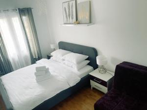 - un lit avec des draps et des oreillers blancs dans une chambre dans l'établissement SoleMare Apartment, à Budva