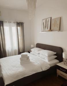 - une chambre avec un lit doté de draps et d'oreillers blancs dans l'établissement SoleMare Apartment, à Budva