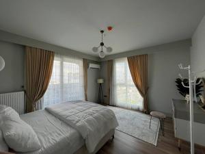 a bedroom with a large bed and large windows at Avenue guest in Buyukcekmece