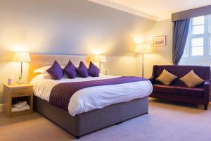 a hotel room with a large bed and a couch at Stoke Rochford Hall in Grantham