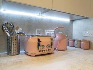 uma torradeira e outros electrodomésticos num balcão de cozinha em Exquisite- stylish- luxurious 2 bed apartment em The Hyde