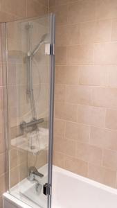 um chuveiro com uma porta de vidro na casa de banho em Exquisite- stylish- luxurious 2 bed apartment em The Hyde