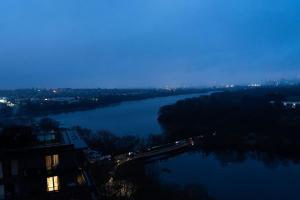 uma vista para um rio à noite com um edifício em Exquisite- stylish- luxurious 2 bed apartment em The Hyde