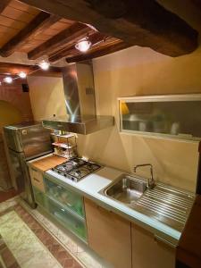 eine Küche mit einer Spüle und einem Herd in der Unterkunft The Small Sweet House in Montepulciano