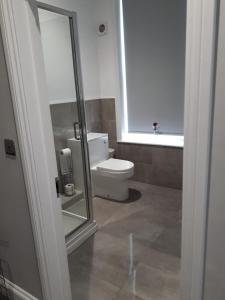 a bathroom with a toilet and a window at Modest Maidstone Gem - Sleeps 3 in Kent