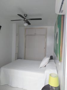 una camera con letto bianco e ventilatore a soffitto di PAUPET a Almería