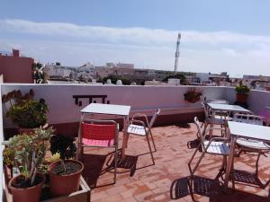 un patio con mesas y sillas en la azotea en PAUPET en Almería