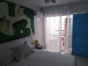 1 dormitorio con 1 cama con puerta azul y ventana en PAUPET, en Almería