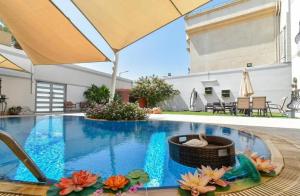 Luxury Private Pool Villa for families only في Sanad: حمام سباحة مع سلة ويكر بجوار منزل