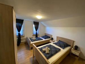 2 camas en un dormitorio con un osito de peluche en la cama en Ferienhaus SüMeer, en Wilhelmshaven