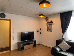 ein Wohnzimmer mit einem Flachbild-TV und einem Sofa in der Unterkunft Ferienhaus SüMeer in Wilhelmshaven