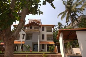 un edificio bianco con un albero di fronte di Thanal at the oceans edge a Varkala