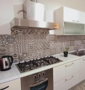 a kitchen with a stove top oven next to a sink at casa di Angela in Acqui Terme