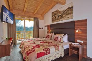 a bedroom with a bed and a large window at Alpen Diamond Penthouse & Apartment in Sölden