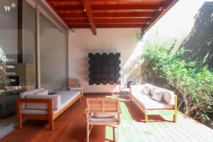 a patio with a couch and a table and chairs at Luxury 3BR House with Terrace in Miraflores in Lima