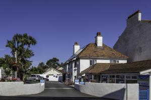 een wit huis met een straat ervoor bij Lyme Bay House in Dawlish