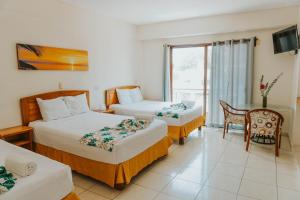 a hotel room with two beds and a table at Casa Chetumal Hotel in Chetumal
