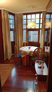 ein Esszimmer mit einem Tisch, Stühlen und Fenstern in der Unterkunft Apartamento en Valgañon in Valgañón