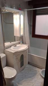 a bathroom with a sink and a toilet and a mirror at Apartamento en Valgañon in Valgañón