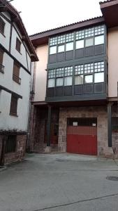 a building with a red door and a red garage at Apartamento en Valgañon in Valgañón