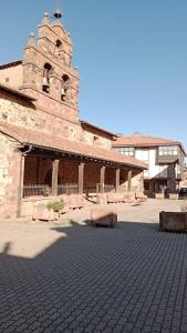 a large brick building with a clock tower on it at Apartamento en Valgañon in Valgañón