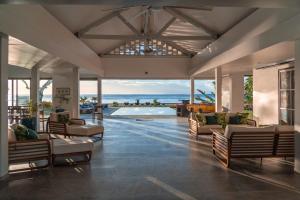 a living room with couches and a view of the ocean at Villa Jessivia in Afareaitu