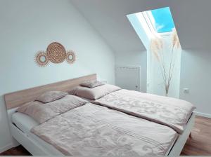 a white bedroom with a bed with a window at Ferienwohnung am Park in Schwabmünchen in Schwabmünchen