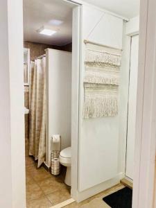 Baño blanco con aseo y toallas en PRIVATE Cozy Guest Suite Near Hard Rock Guitar, en Fort Lauderdale