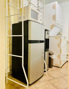 a kitchen with a refrigerator and a microwave at PRIVATE Cozy Guest Suite Near Hard Rock Guitar in Fort Lauderdale