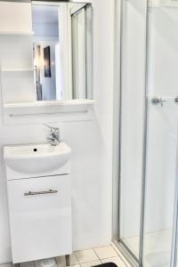 een witte badkamer met een wastafel en een douche bij The Commercial Hotel Wallerawang in Wallerawang