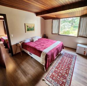 um quarto com uma cama grande e uma janela em Pousada Bliss House - Opções de suites com hidromassagem em Campos do Jordão