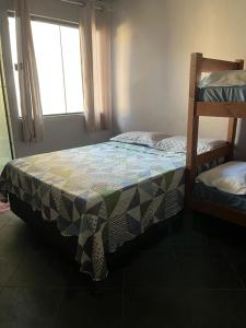 a bedroom with two bunk beds and a window at POUSADA ONDA CARIOCA in Cabo Frio