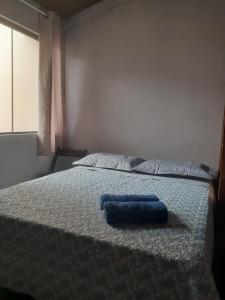 Una cama con una toalla azul encima. en POUSADA ONDA CARIOCA, en Cabo Frío